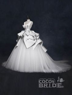 a white wedding dress on display in front of a dark background