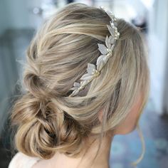 a woman wearing a hair comb with flowers on it's head and blonde hair