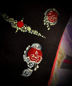 two pieces of black paper with red and white designs on them