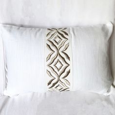 a white pillow with an embroidered design on it