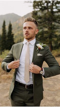 a man in a suit and tie is posing for the camera with his hands on his hips