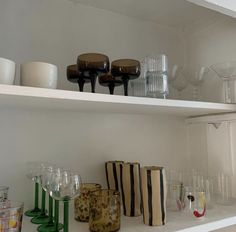 several glasses and vases are sitting on the shelves