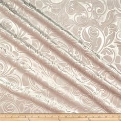 an image of a white fabric with swirls and scrolls on the side, as well as a ruler