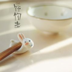 a small rabbit figurine next to chopsticks on a table