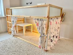 a child's loft bed with curtains and desk