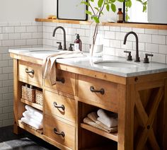 a bathroom with two sinks and wooden cabinets