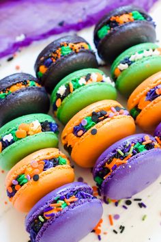 colorful macaroons with sprinkles are arranged on a plate