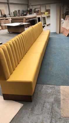 a yellow couch sitting on top of a blue floor