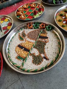 a table topped with lots of different types of food on top of metal pans