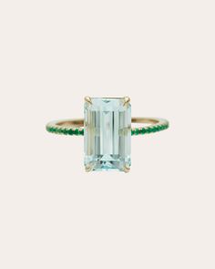 an emerald and diamond ring on a white background