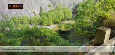 an aerial view of a river surrounded by trees and mountains in the background with text overlay