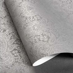 an image of a wallpaper with silver and white designs on the paper, which is rolled up