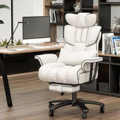 a white office chair sitting in front of a desk with a computer monitor and bookshelf