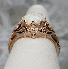 Simulated Opal Ring Daisy Design #66 Custom Made Inspired by the Art Nouveau movement of the early 20th century, I now offer this lovely reproduction filigree ring in sterling silver & rose gold plating. This gorgeous ring is set with a flawless simulated opal; which has great shine and perfect clarity. The round full cut opal is 8mm (5/16th of an inch) in diameter. The ring measures 12mm NS on the finger. The inside of the band is marked 925 for sterling. Notice the beautiful daisy of the s Vintage White Jewelry For Ceremonial Occasions, Ornate White Filigree Ring With Intricate Design, White Victorian Jewelry For Ceremonial Occasion, Vintage Rose Gold Jewelry With Intricate Design, Vintage Rings With Intricate Design For Marriage, Antique White Filigree Ring For Formal Occasions, Vintage Marriage Rings With Intricate Design, White Heirloom Filigree Ring With Intricate Design, Vintage Wedding Rings With Intricate Design