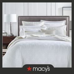 an image of a bed with white sheets and pillows in the middle, on display at macy's