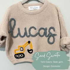 a sweater with the word lucas written on it and a construction vehicle drawn on it