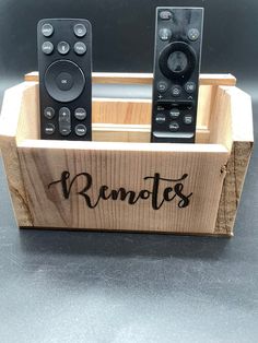 two remote controls in a wooden box with the word remotes written on it,