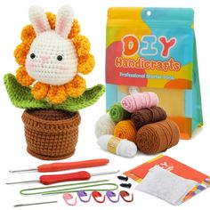 a crochet kit with yarn, scissors and a stuffed animal sitting in a pot