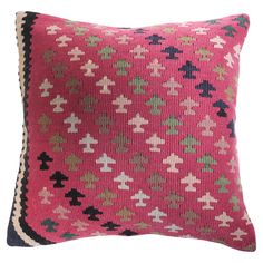 a pink pillow with black and green designs on it