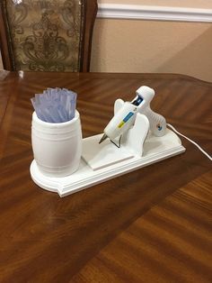 a table that has a glass and some kind of device on it, sitting on top of a wooden table