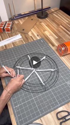 a person is drawing on a table with scissors