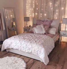 a bed with white sheets and pillows in a room filled with lights on the wall