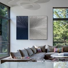 a living room filled with furniture and large windows