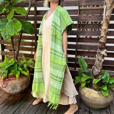 Handwoven poncho handmade from a 100% Indian cotton in a warm jungle green color. This is a one of the kind, planet-loving intentional piece. This kimono is a true collaboration of the women crafting together and co-weaving and passing on the ancient world textile traditions. The threads are handwoven by the artisans in India, the embroidery accents are hand-stitched by the women from Kuna Tribe in Panama where they weave in their prayers and dreams into the patterns and designs, and the poncho Bohemian Green Poncho For Spring, Green Bohemian Poncho For Spring, Casual Beach Shawl Poncho, Green Shawl Poncho One Size, Green Shawl For Beach, Green One-size Shawl Poncho, Green Oversized Poncho, Green One Size Poncho For Summer, Green Shawl For Beach In Spring