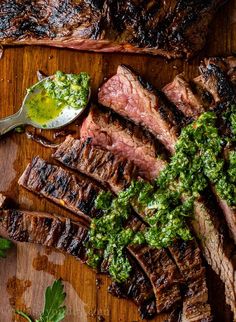 grilled steaks with chimica sauce and parsley on a cutting board