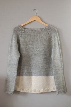 a gray sweater hanging on a wall