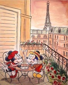 two mickey mouses sitting at a table in front of the eiffel tower