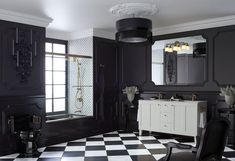 a black and white bathroom with checkered flooring, chandelier, mirror, sink, toilet and shower