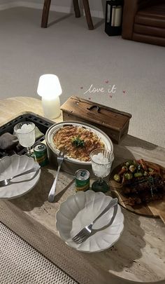 a table topped with plates and bowls filled with food on top of a wooden tray