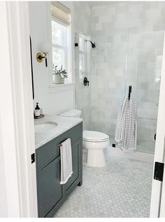 an instagramted photo of a bathroom with gray and white fixtures