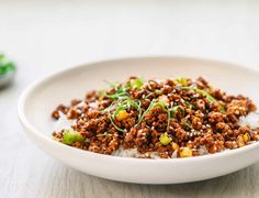 a white bowl filled with rice and meat