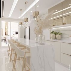 a white kitchen with marble counter tops and stools next to a bar in the middle