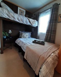 a bedroom with bunk beds and curtains on the windowsills is pictured in this image