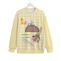 a yellow sweatshirt with an image of flowers, carrots and other things on it