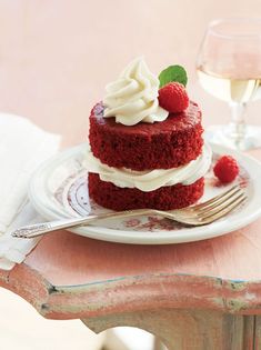 a red velvet cake with whipped cream and raspberries