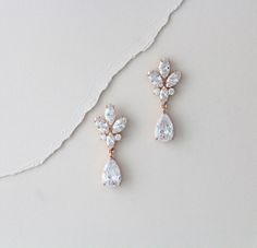 "Simply stunning ! These rose gold bridal earrings will take your breath away with rose gold finish and Swarovski Pure Brilliance stones in various shapes and sizes. Available in 3 finishes. Beautiful addition to your wedding day or a great gift for your bridesmaids ! Earrings measure 1.5\" and are 5/8\" wide Matching necklace: https://www.etsy.com/listing/456981526/bridal-backdrop-necklace-rose-gold?ref=shop_home_active_6 https://www.etsy.com/listing/565158619/rose-gold-necklace-bridal-necklace Delicate Rose Gold Diamond Earrings For Anniversary, Rose Gold Dangle Diamond Earrings For Anniversary, Rose Gold Dangle Earrings For Anniversary, Rose Gold Dangle Crystal Earrings For Anniversary, Dainty Rose Gold Bridal Earrings, Anniversary Rose Gold Dangle Crystal Earrings, Rose Gold Teardrop Bridal Earrings For Anniversary, Rose Gold Cubic Zirconia Wedding Earrings, Rose Gold Cubic Zirconia Earrings For Wedding