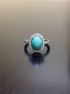 a turquoise ring sitting on top of a wooden table