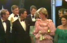 a group of people standing next to each other wearing tuxedos and bow ties