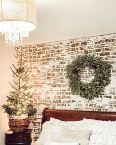 a bedroom with a brick wall and a wreath on the headboard next to a bed