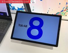 a tablet with the number 8 on it next to a laptop