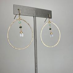 Details: ~Gold filled. ~Hand hammered hoops.~Ombre rubies or emeralds.~Rainbow moonstones.~Hoops measure approximately 1 1/2" in diameter.~Earrings measure approximately 2 1/4” from the top of the hook to the bottom of the bottom hoop. This piece has a beautiful companion piece, the Oombré Lariat. You can also order the entire set together here. The Hook, Moon Stone, Rainbow Moonstone, Gold Filled, Ruby, Emerald, Hoop Earrings, Rainbow, Gemstones