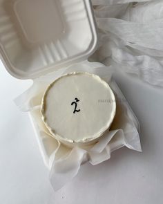 a white cake in a plastic container with an anchor on it