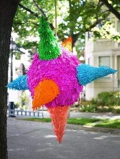 a colorful paper bird hanging from a tree