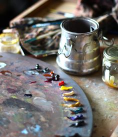 the paintbrushes are sitting on the table next to some jars