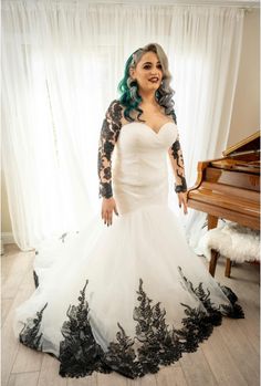 a woman in a wedding dress standing next to a piano