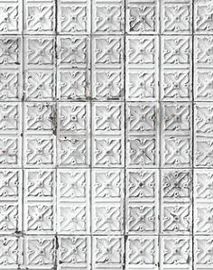 an old white tile wall with many different designs